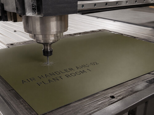 LYS-7033 thin olive black identification sheet being engraved on a realistic large CNC machine for an air handler plate