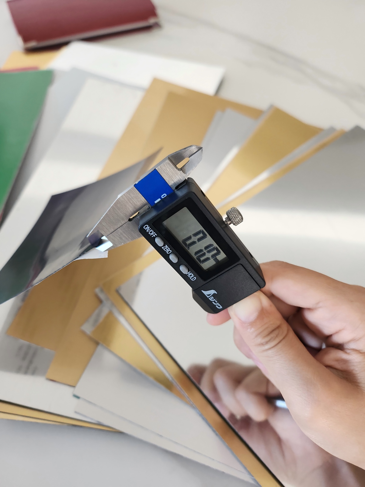 Digital caliper checking the thickness of a LYSHIRE engraving plastic sheet