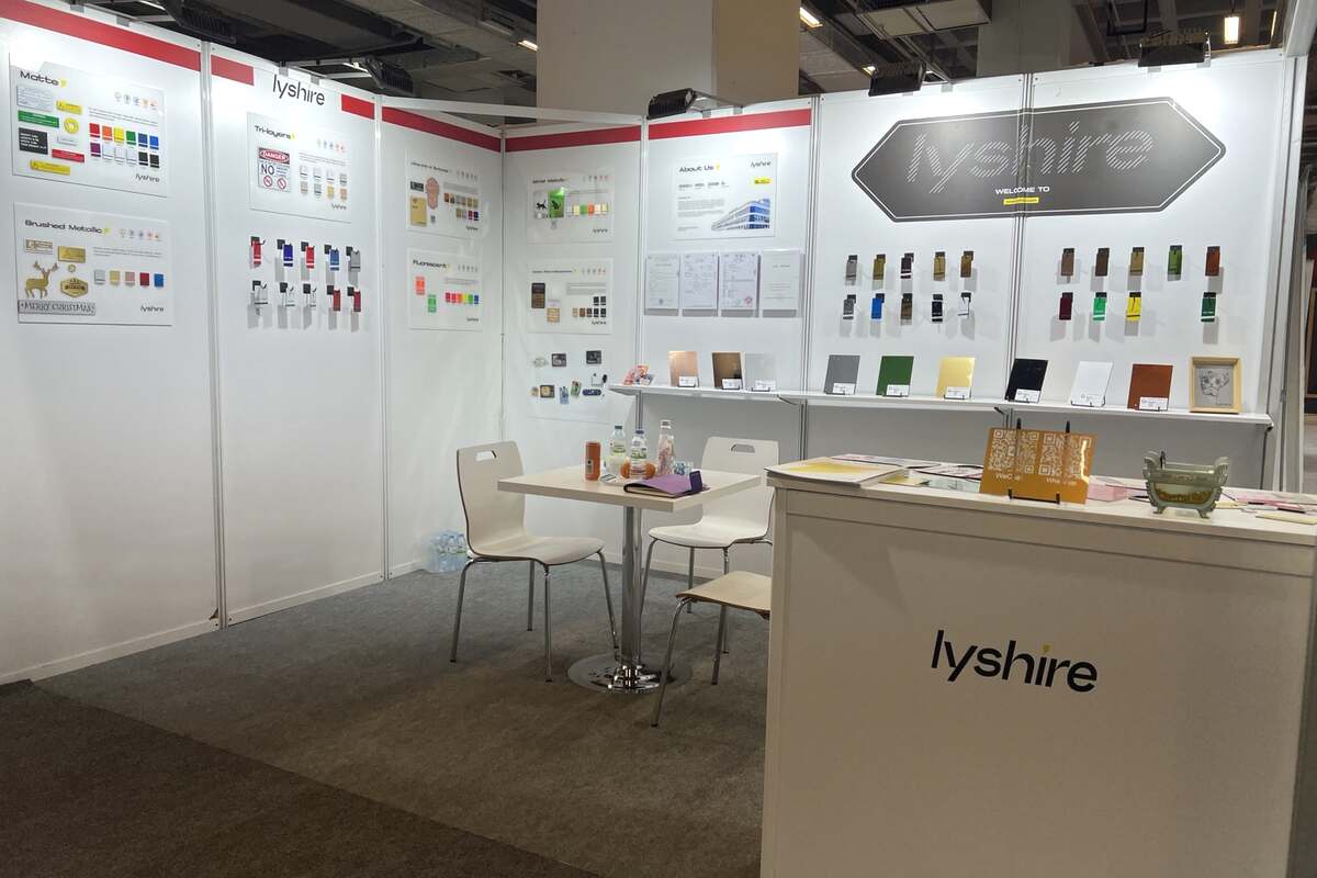 Real LYSHIRE booth displaying engraving sheets and application samples at SIGN Istanbul 2025