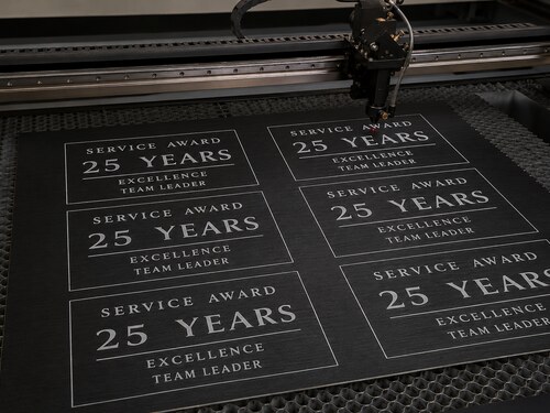 LYS-8272 brushed black white core laminate processed as service award inserts on a realistic large CO2 laser honeycomb table