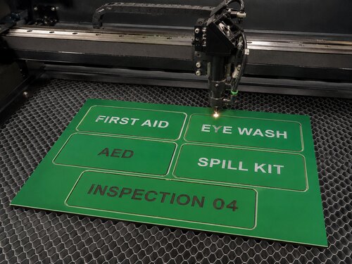 LYS-GWB004 green white black tri-layer sheet processed into emergency equipment panels on a large CO2 laser honeycomb table